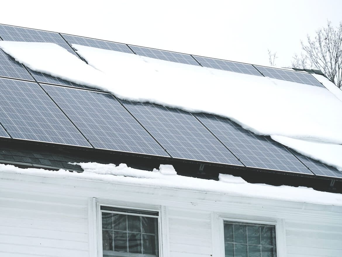 Photovoltaikanlage auf einem verschneiten Dach im Winter
